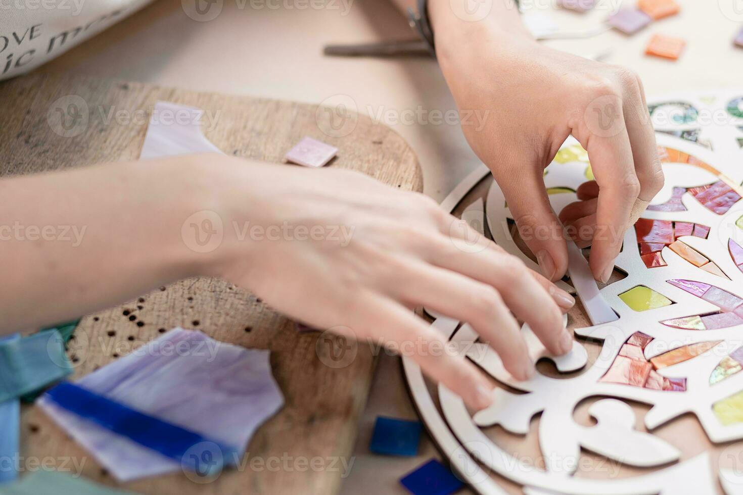 Hands of master working on new modern colorful mosaic. Close-up photo