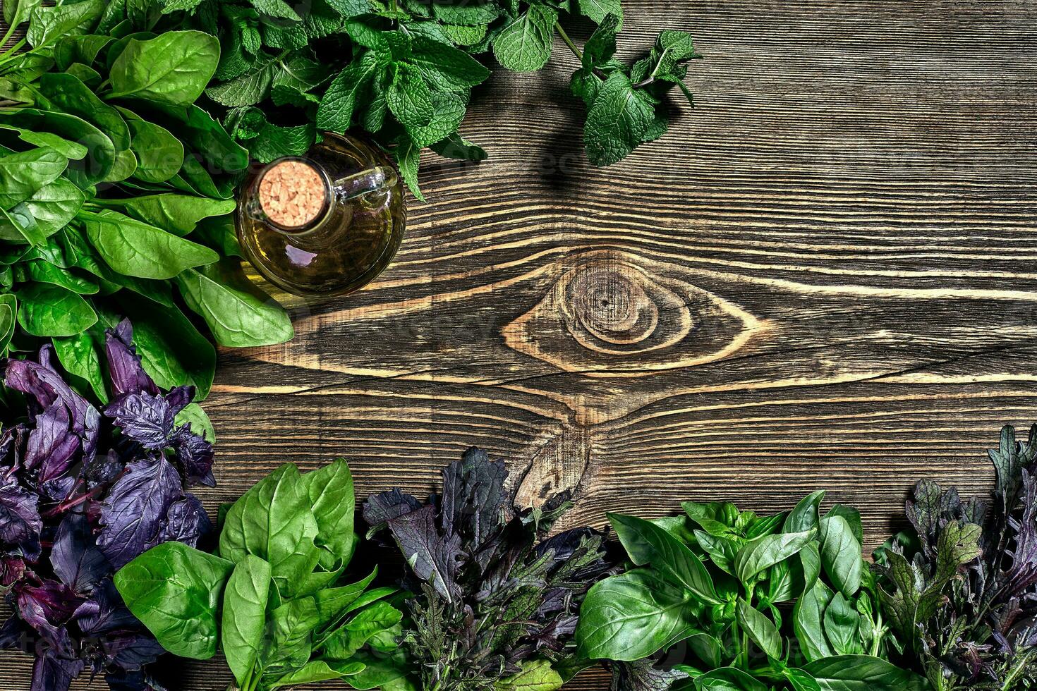 Variety of fresh organic herbs on wooden background. Freshly harvested herbs including basil, arugula. Top view. Copy space. photo