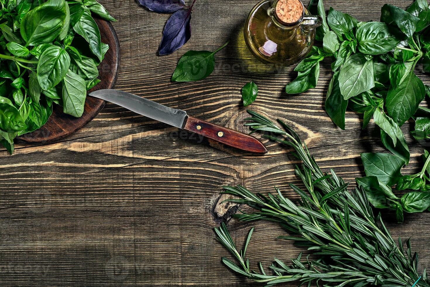 Variety of fresh organic herbs on wooden background. Freshly harvested herbs including basil, rosemary. Top view. Copy space. photo