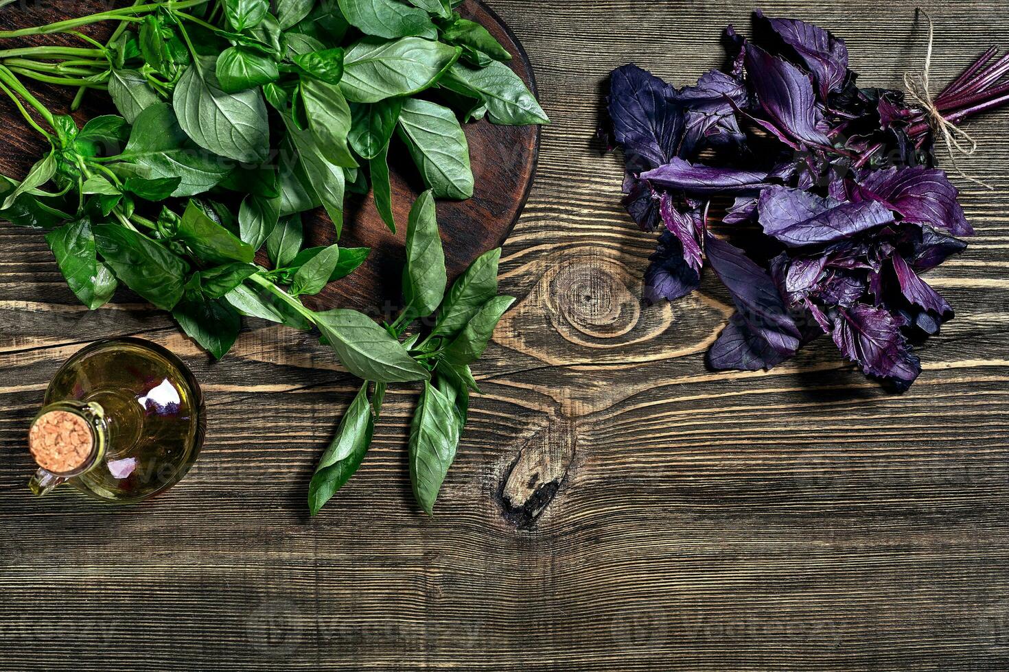 Green and purple fresh basil on wooden background. Top view photo