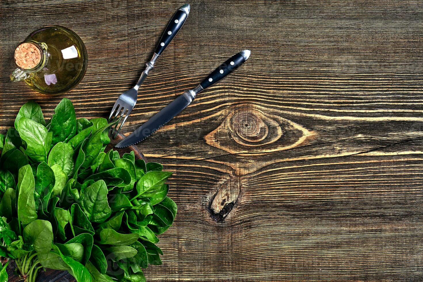 Spinach baby leaves on wooden background. Top view. Copy space photo