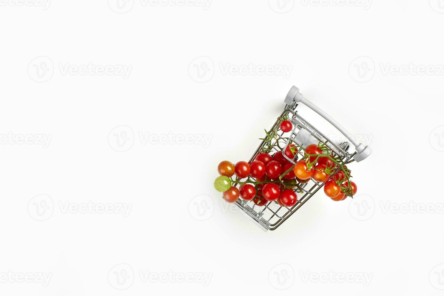 Shopping trolley full of tomatoes on white background photo