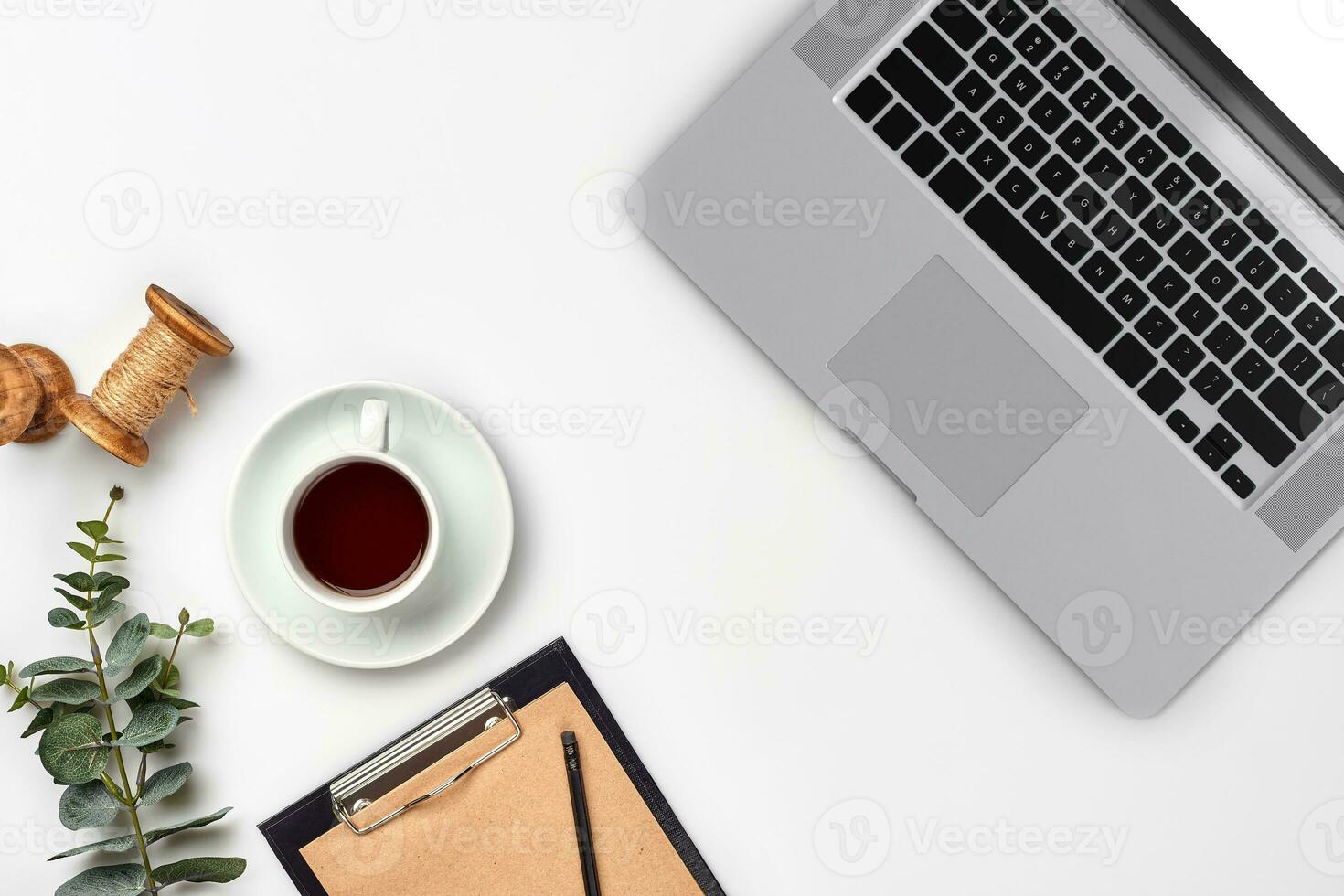 Notepad with pen and cup of tea on white table. Working space. Handmade. Top view, flat lay. photo