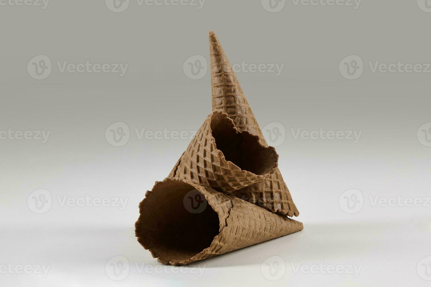 Three empty, tasty, brown wafer cones for ice cream isolated on white. Concept of food, treats. Mockup, template for advertising and design. Close up photo