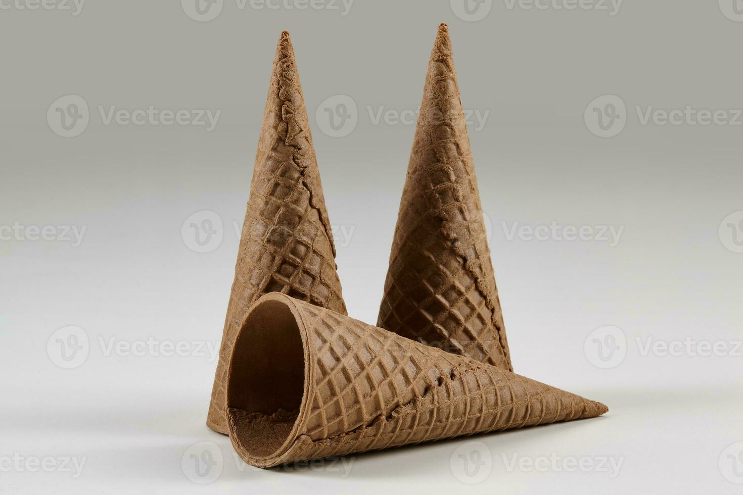 Three empty, big, chocolate wafer cones for ice cream isolated on white. Concept of food, treats. Mockup, template for advertising or design. Close up photo