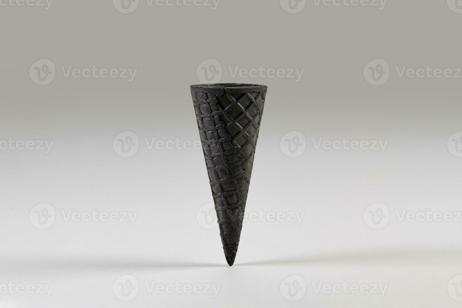 Empty, sweet, black wafer cone for ice cream isolated on white. Concept of food, treats. Mockup, template for advertising and design. Close up photo