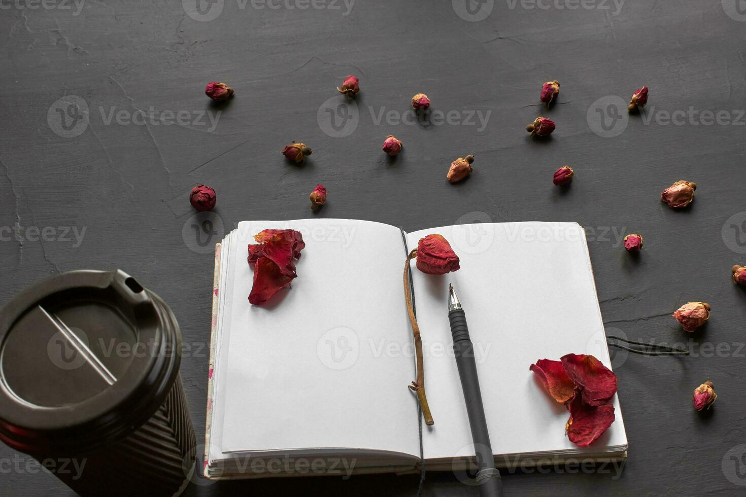 Top view of an empty notebook, scrapbook accessories and a cup of coffee on a black background. photo