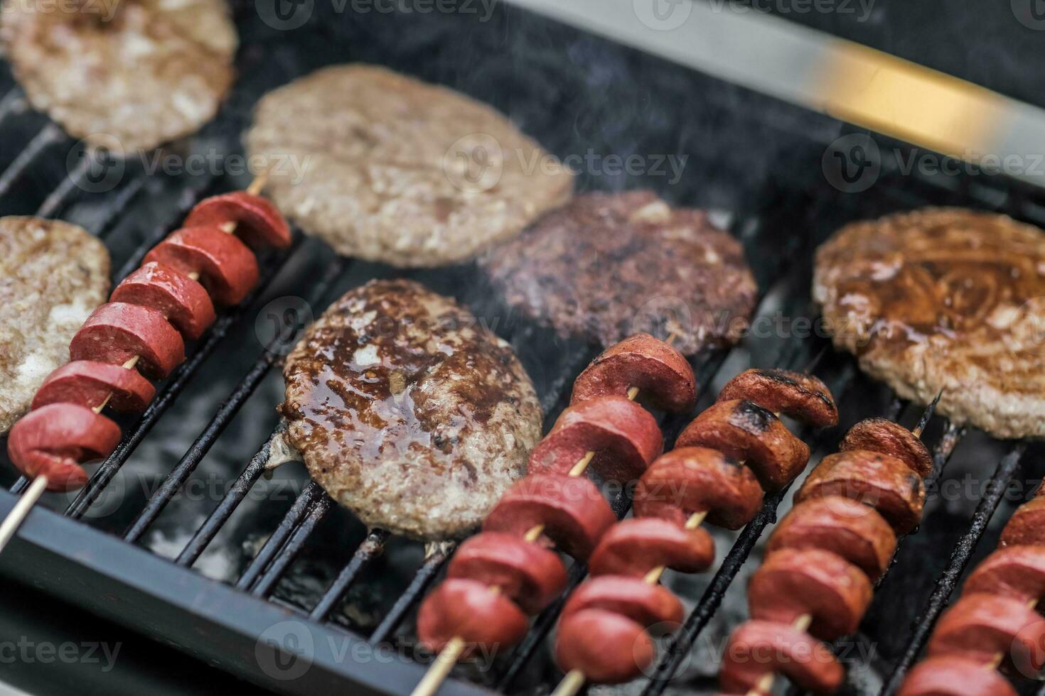 Barbecue grill with delicious grilled meat and sausages, closeup photo