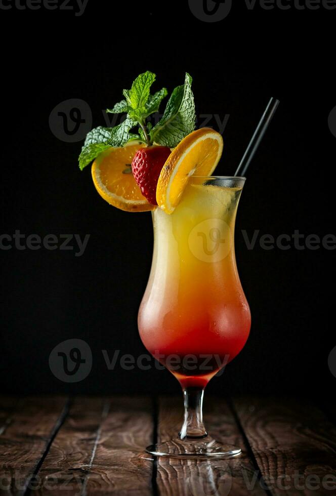 Cocktail with orange, strawberry and mint on a dark background photo