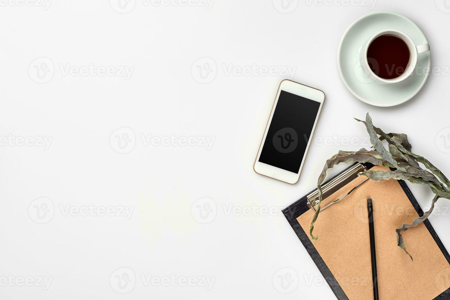 Notepad with pen and cup of tea on white table. Working space. Handmade. Top view, flat lay. photo