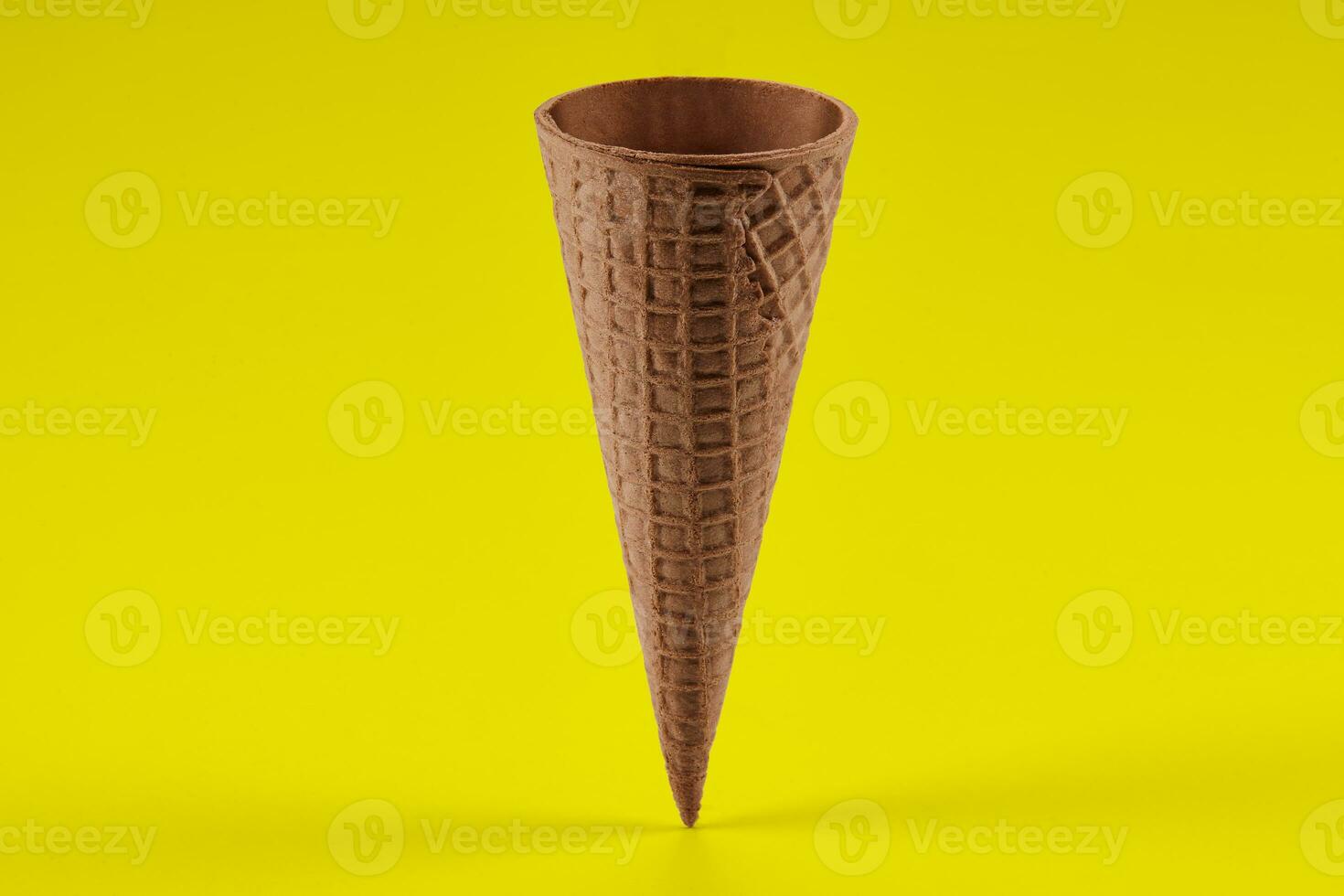 Empty, sweet wafer cone for ice cream against yellow background. Concept of food, treats. Mockup, template for your advertising and design. Close up photo