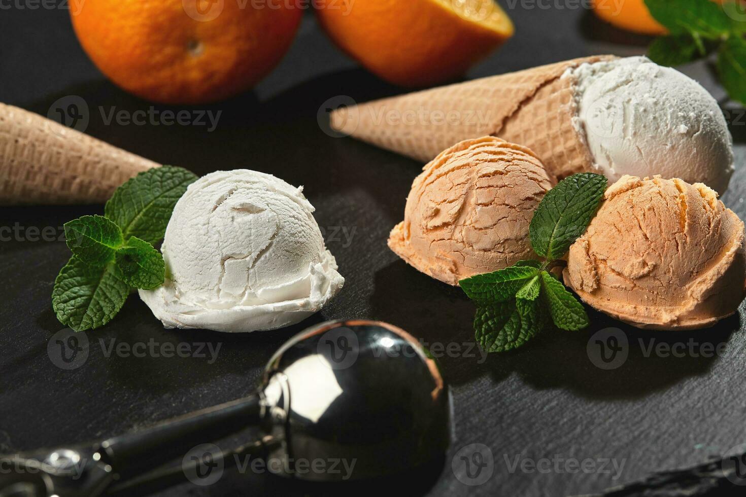Close-up shot of a creamy and orange ice cream served on a dark slate, black background. photo