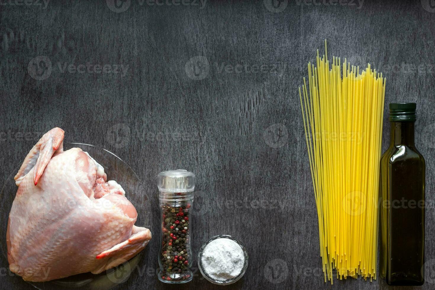 Pasta ingredients. Chicken breasts, spaghetti pasta on the wooden table. Space for text. photo