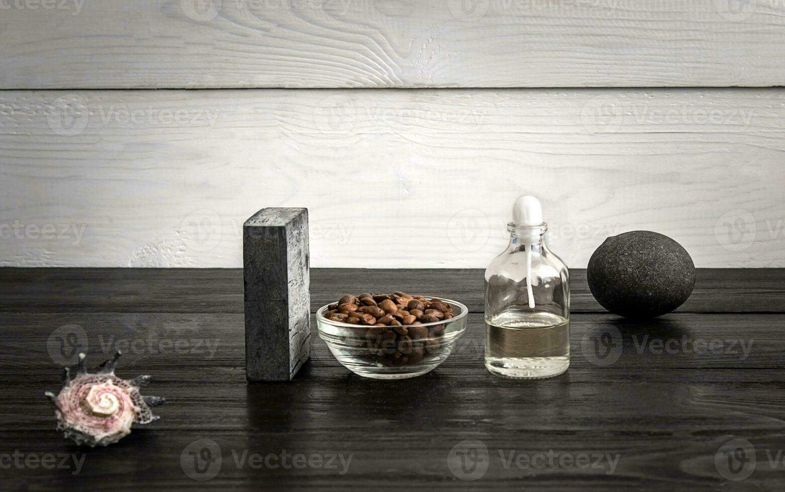 Composition of oil bottles and soap on black wooden background photo