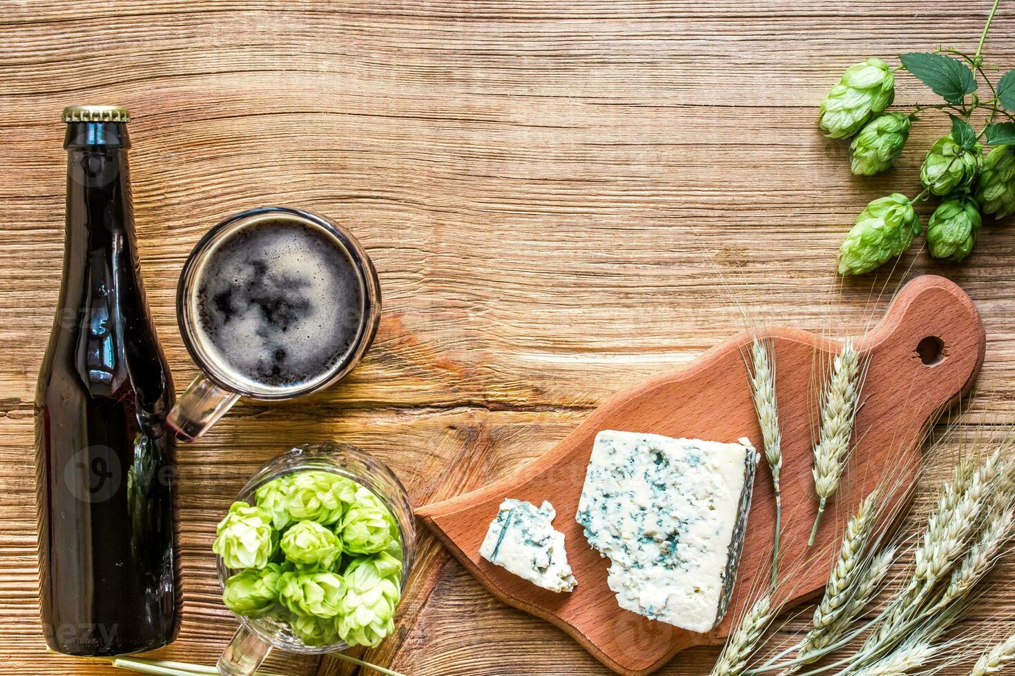 Beer background. Fresh beer and the salty cheese on a wooden table. Top view photo