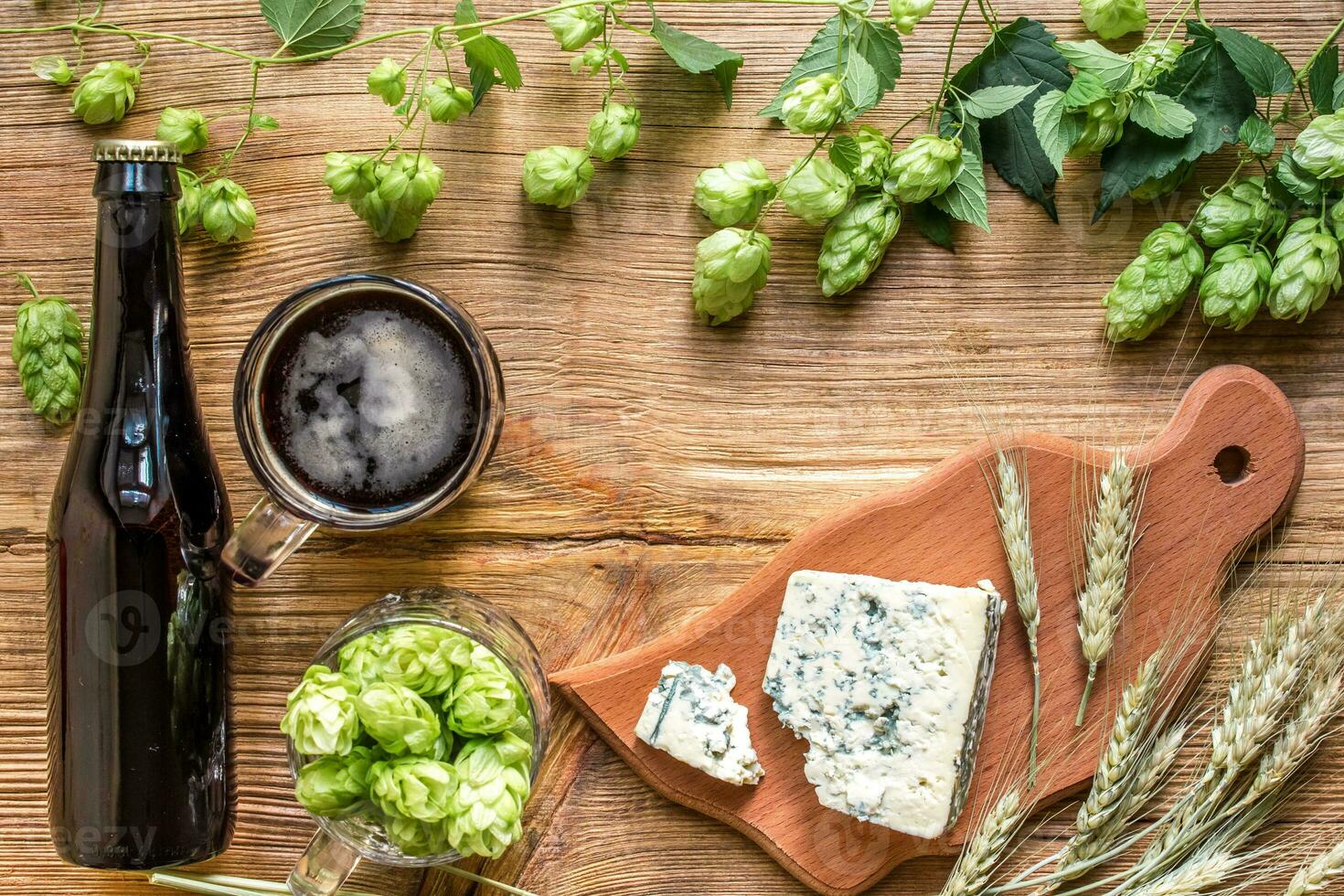 Beer background. Fresh beer and the salty cheese on a wooden table. Top view photo