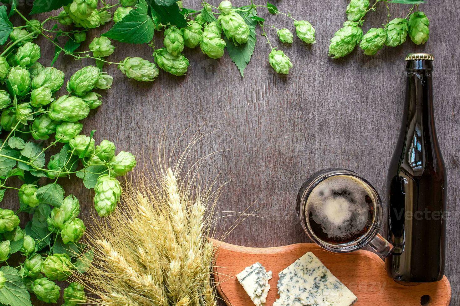 Beer background. Fresh beer and the salty cheese on a wooden table. Top view photo