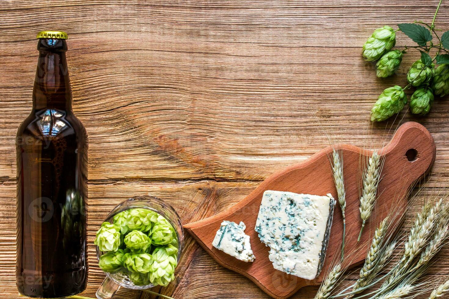 Beer background. Fresh beer and the salty cheese on a wooden table. Top view photo