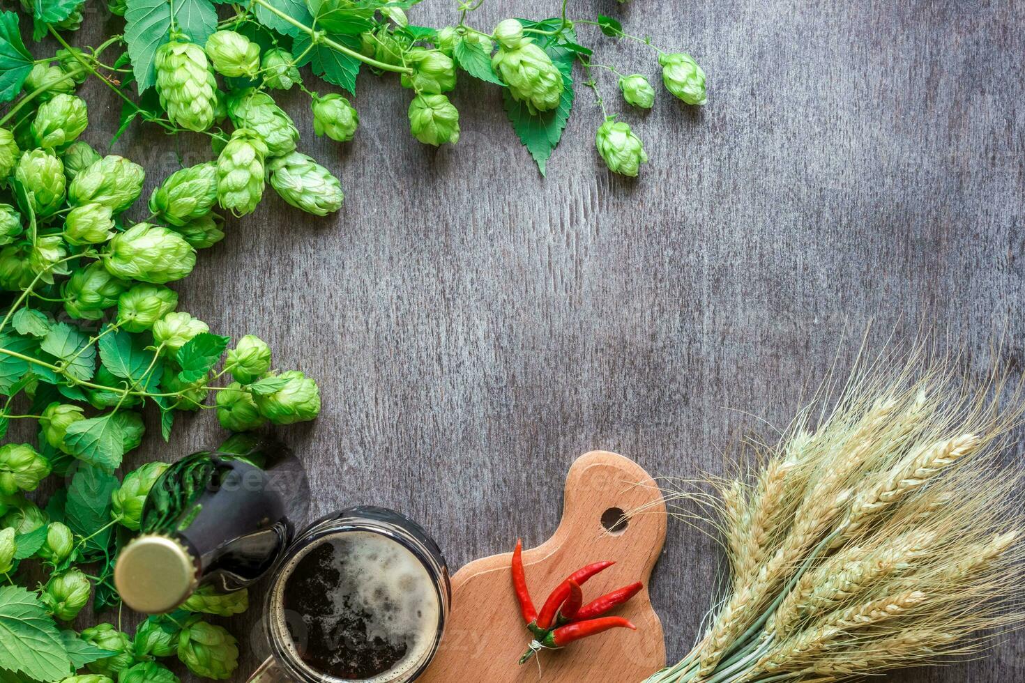 Bottle and glass beer with wheat and hops as brewing ingredients in top view and copy space area photo