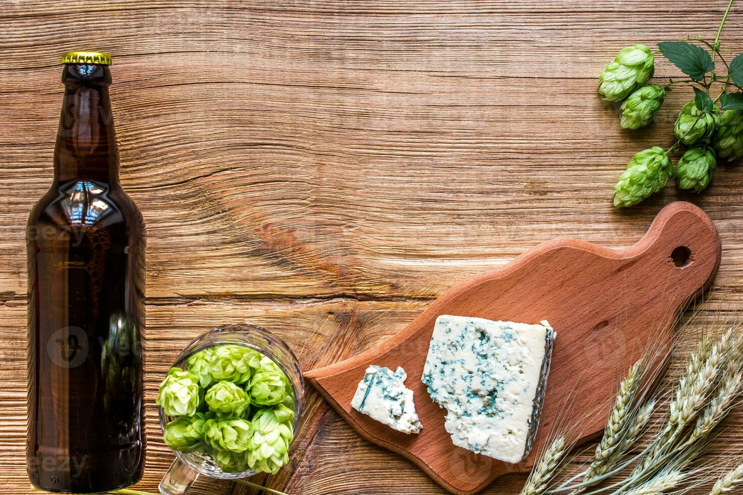Beer background. Fresh beer and the salty cheese on a wooden table. Top view photo