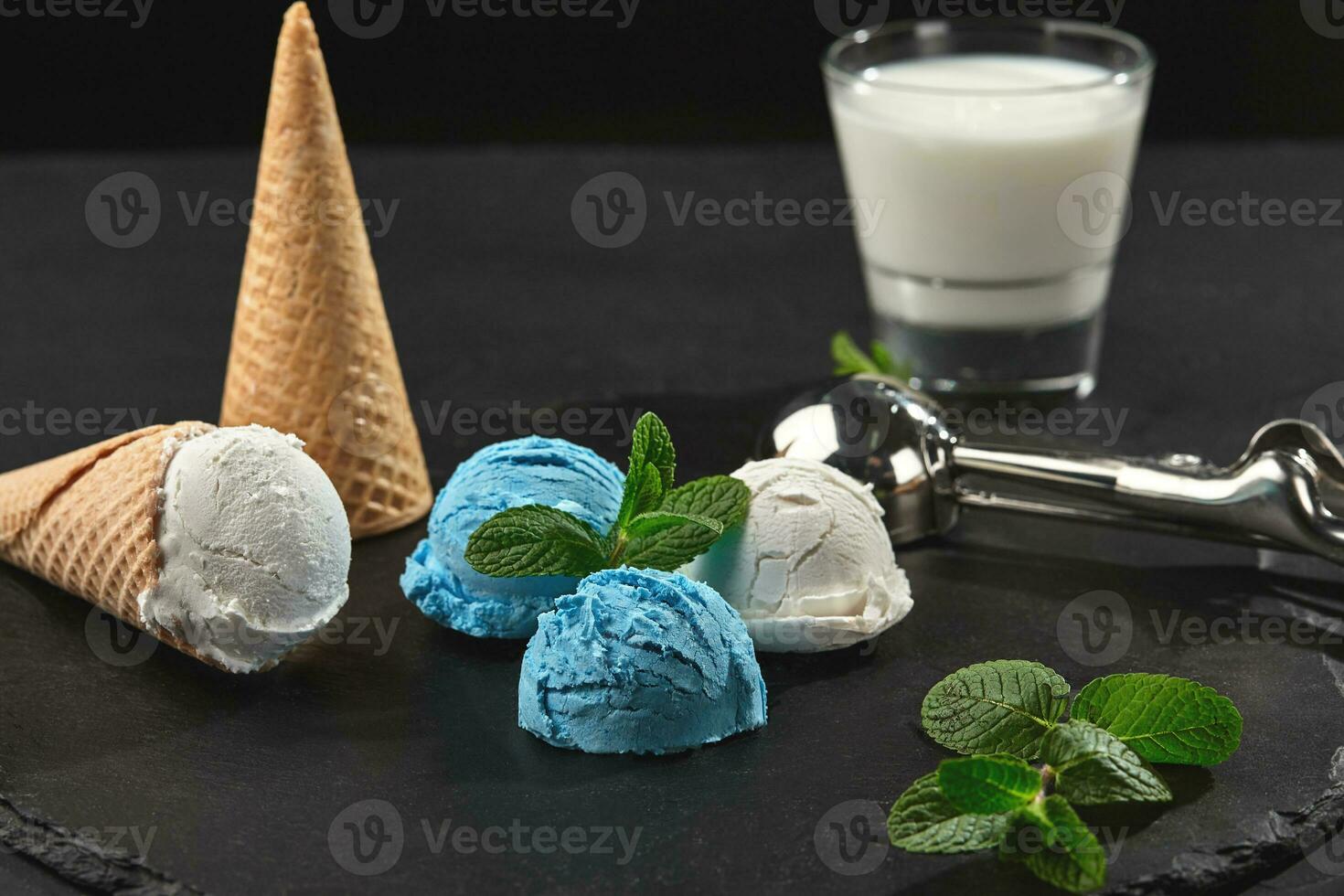 Close-up shot of a creamy and blueberry ice cream served on a dark slate, black background. photo