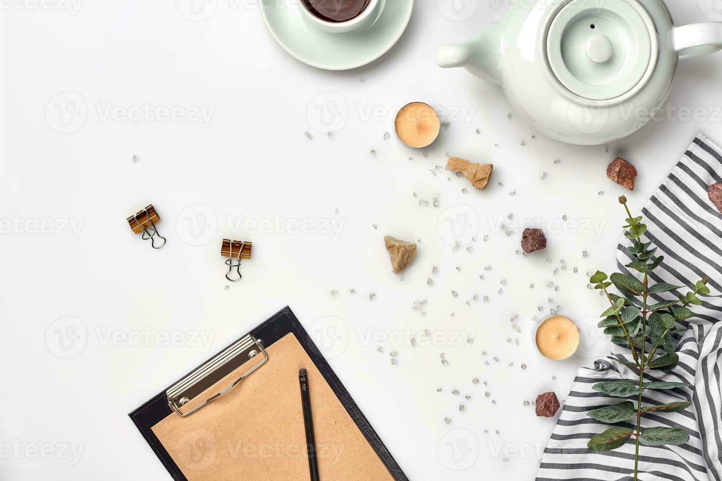 Opened diary with pen on the table near hot cup of black tea photo