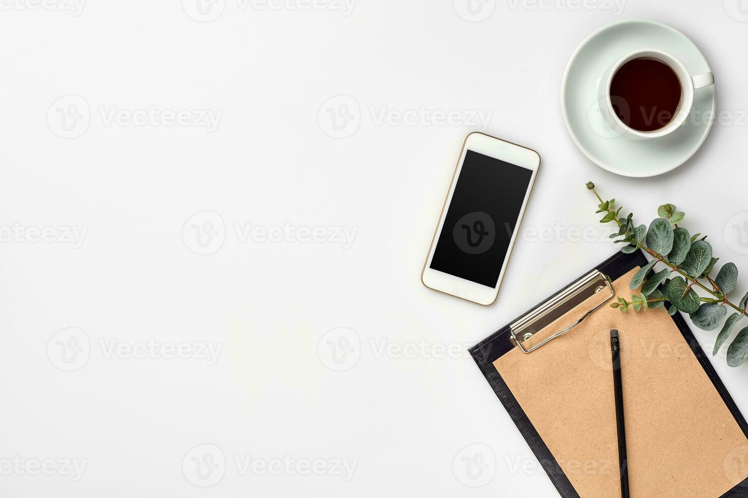 Notepad with pen and cup of tea on white table. Working space. Handmade. Top view, flat lay. photo