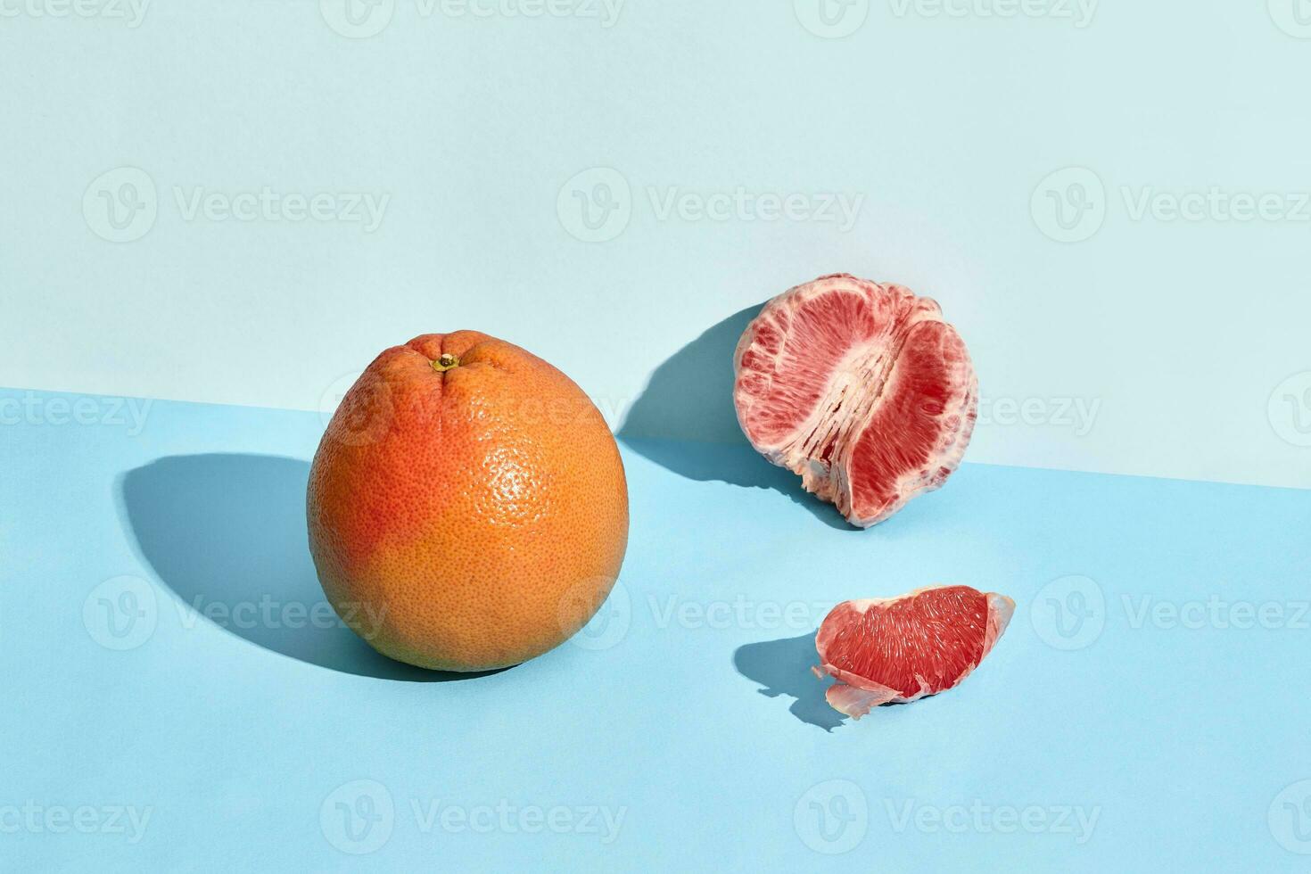 Grapefruit citrus fruit with half on blue photo