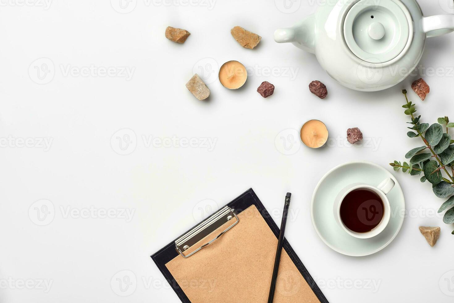 Opened diary with pen on the table near hot cup of black tea photo