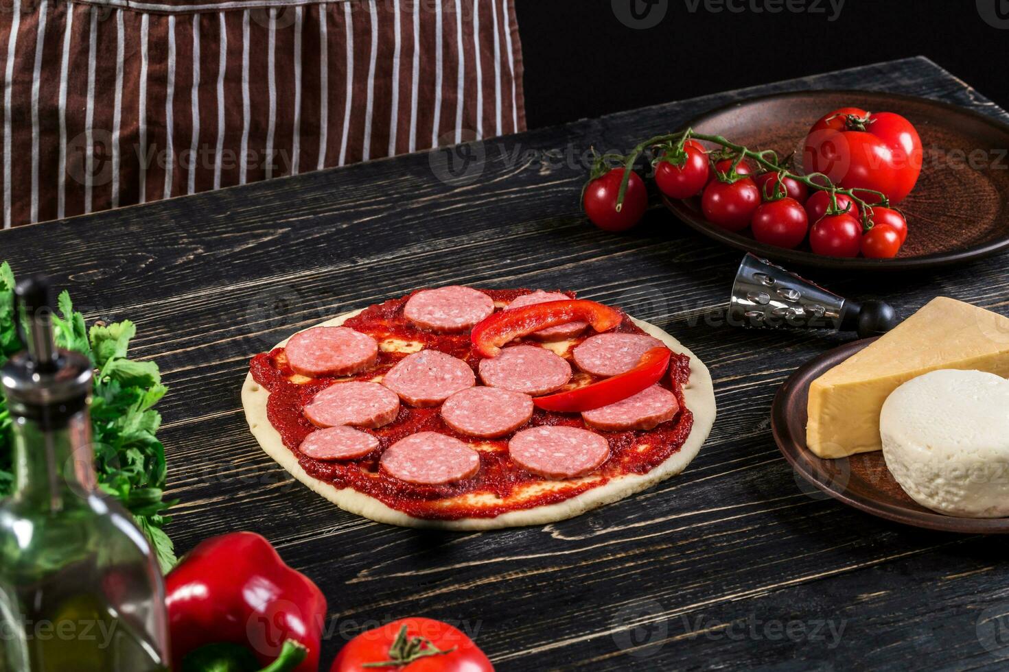 cocinar en el cocina poniendo el ingredientes en el Pizza. Pizza concepto. producción y entrega de alimento. foto