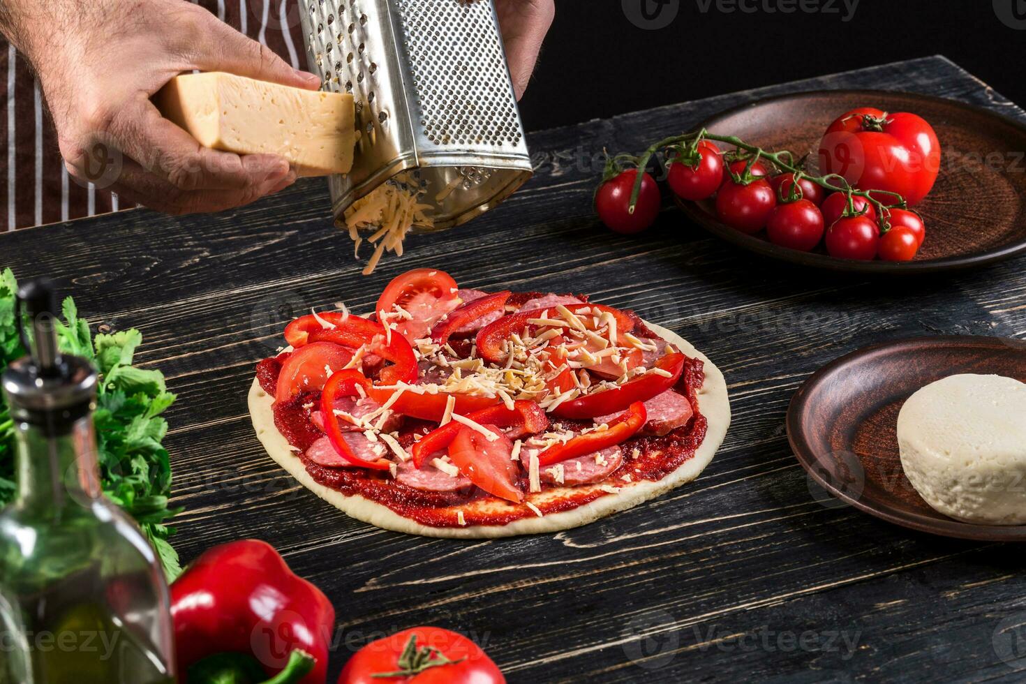 cocinar en el cocina poniendo el ingredientes en el Pizza. Pizza concepto. producción y entrega de alimento. foto