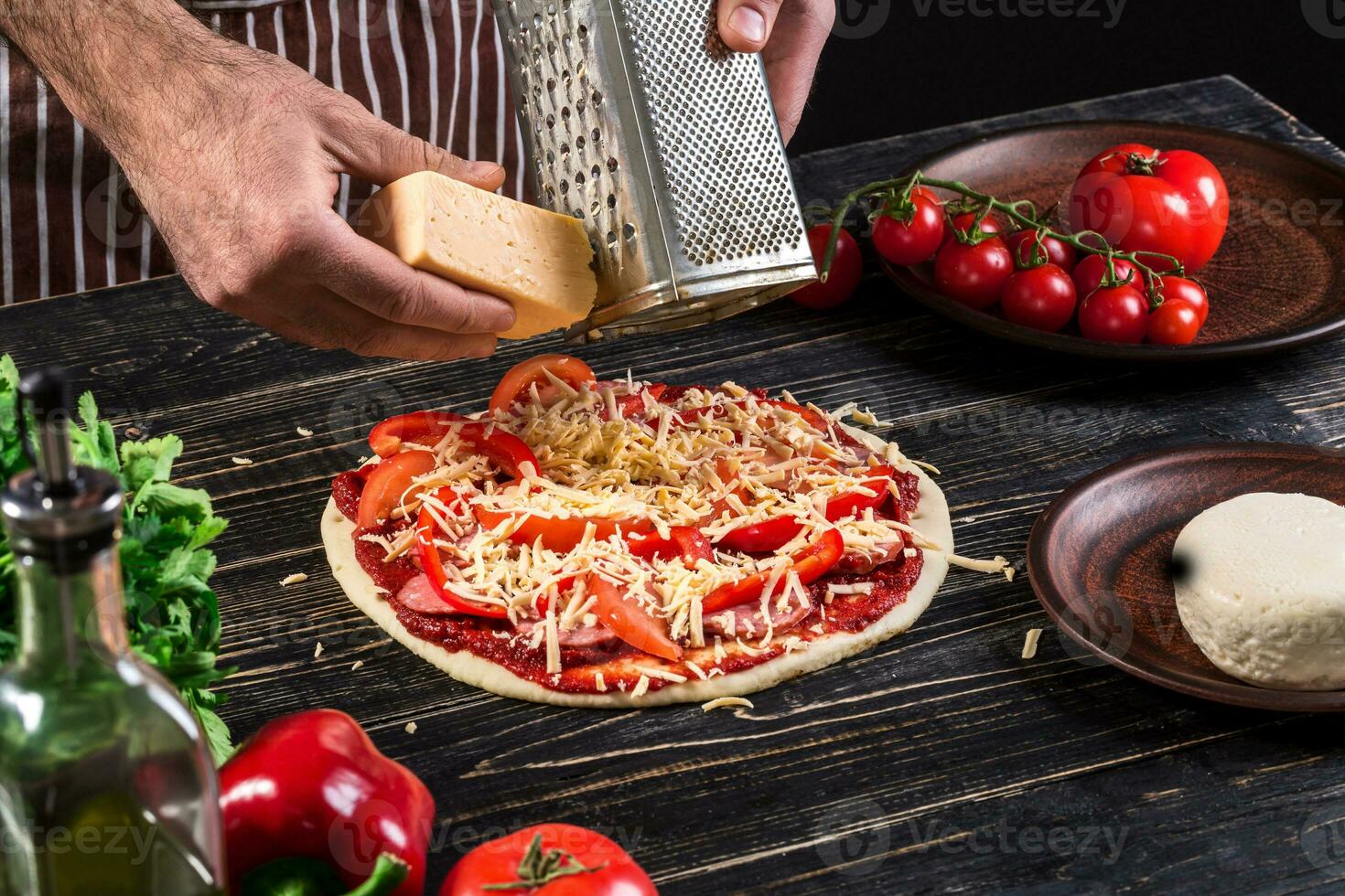 cocinar en el cocina poniendo el ingredientes en el Pizza. Pizza concepto. producción y entrega de alimento. foto