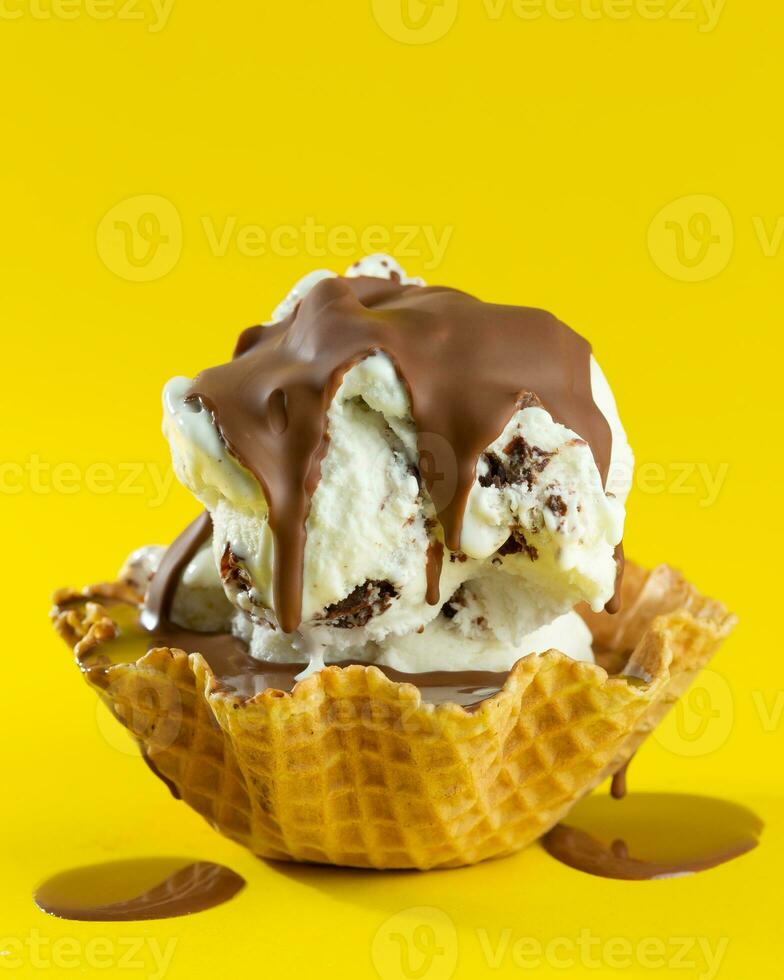 hielo crema con chocolate y nueces en gofre cono en amarillo antecedentes foto