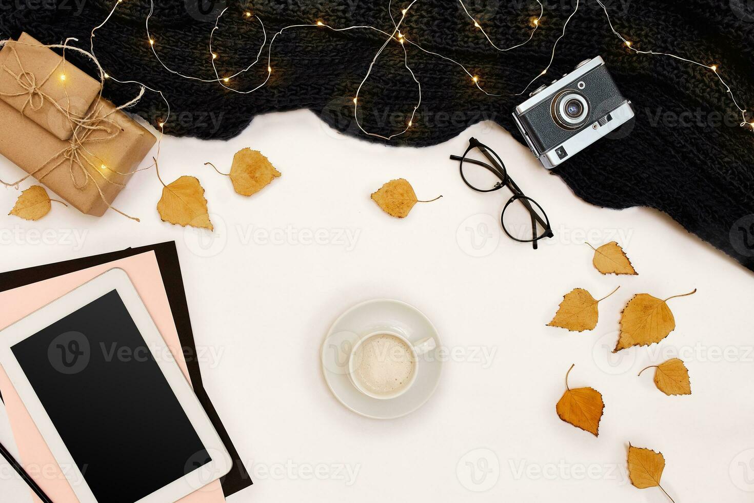 Autumn concept, dried fall leaves, mug of cocoa, old camera, scarf and tablet with blank screen. Mock up photo