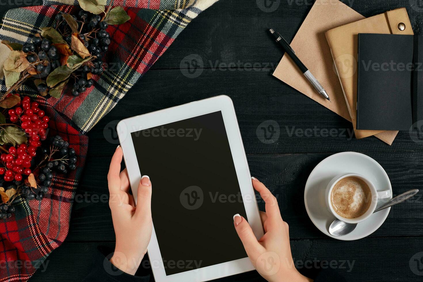 Women hands holding the tablet with black screen above the table with a cup of coffee and smart photo