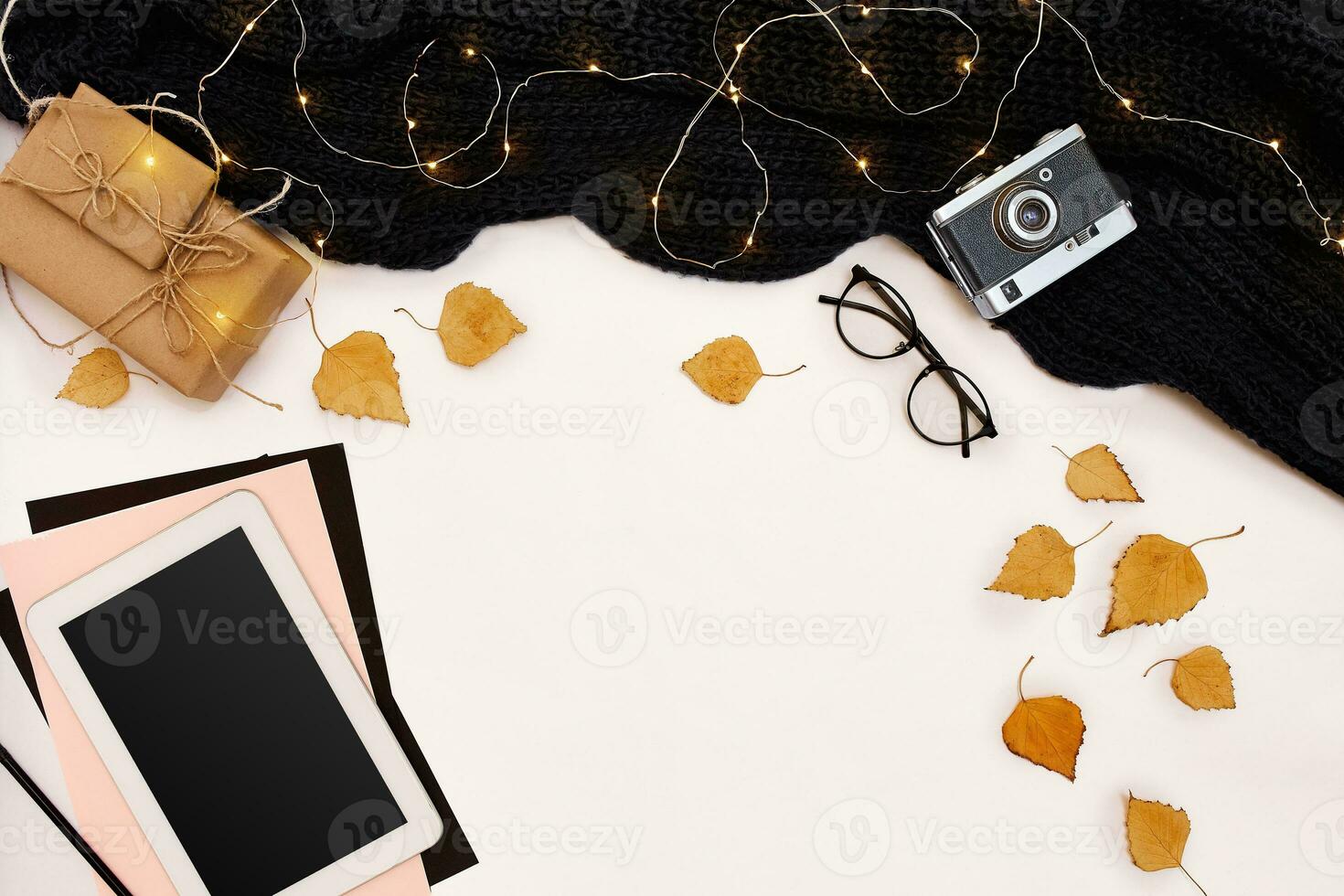 Autumn concept, dried fall leaves, mug of cocoa, old camera, scarf and tablet with blank screen. Mock up photo