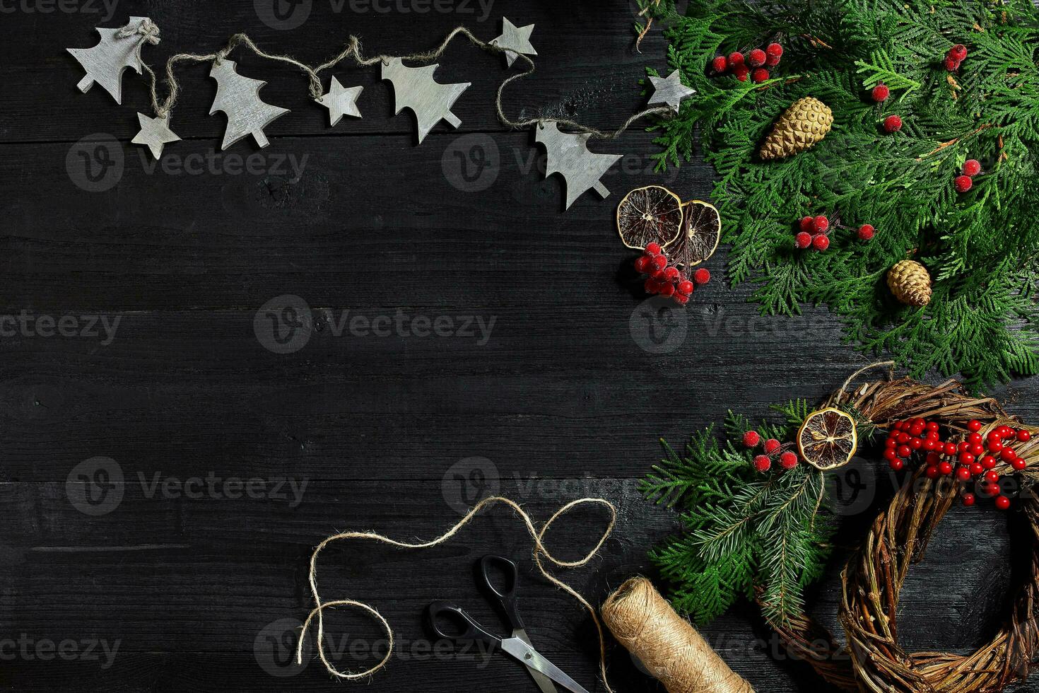 Make a Christmas wreath with your own hands. Spruce branch, Christmas wreath and gifts on a black wooden background photo