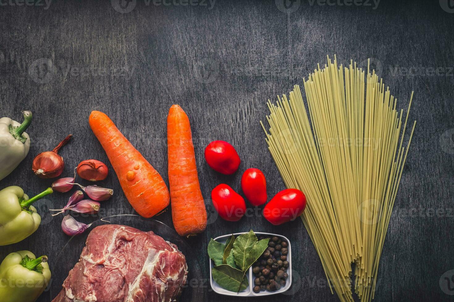 Raw meat beef with spaghetti, fresh organic vegetables, onion, garlic, spices, peppercorns, rosemary, salt, tomatoes and dill for cooking pasta. Top view. photo