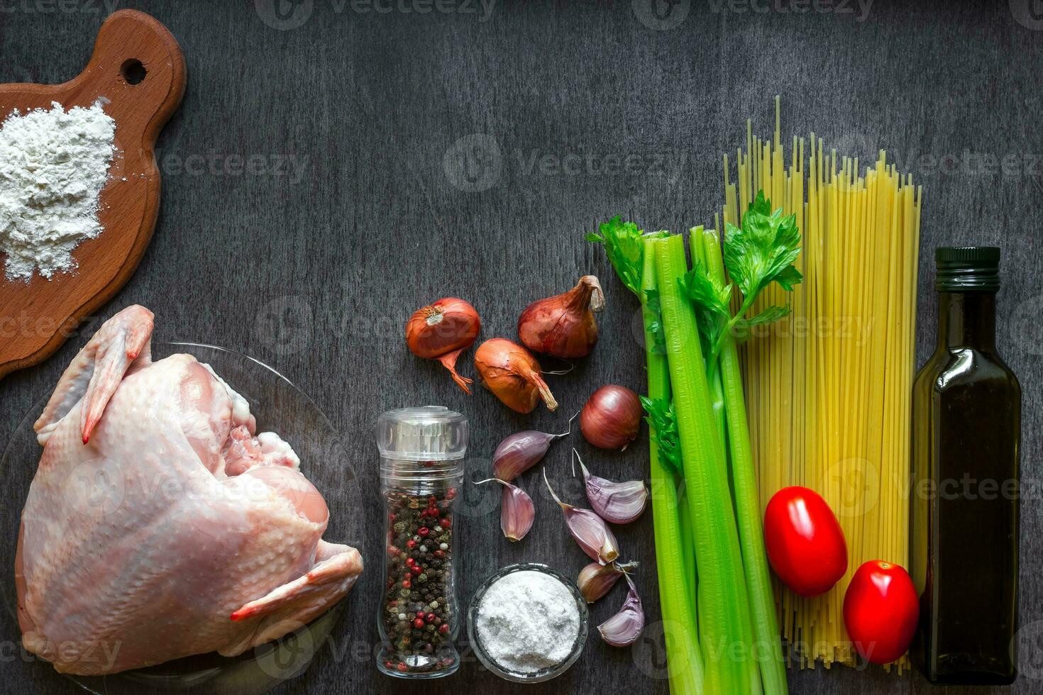 pasta ingredientes. pollo pechos, Cereza Tomates, espaguetis pasta, elery, especias y ajo en el de madera mesa. espacio para texto. foto