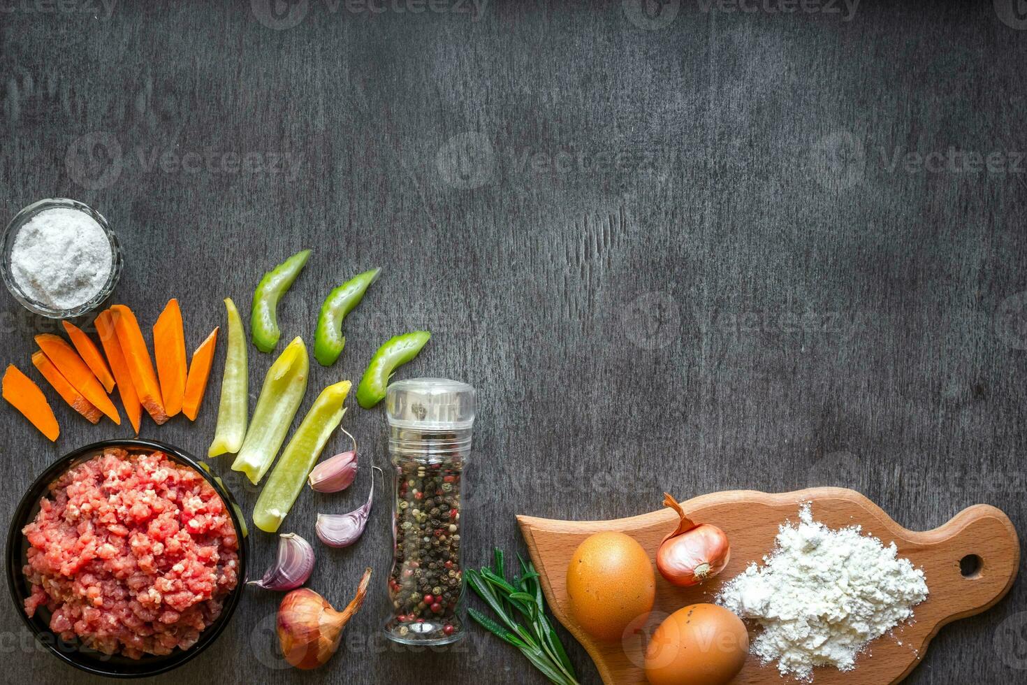 Composition of raw meat with vegetables and spice on wooden background photo