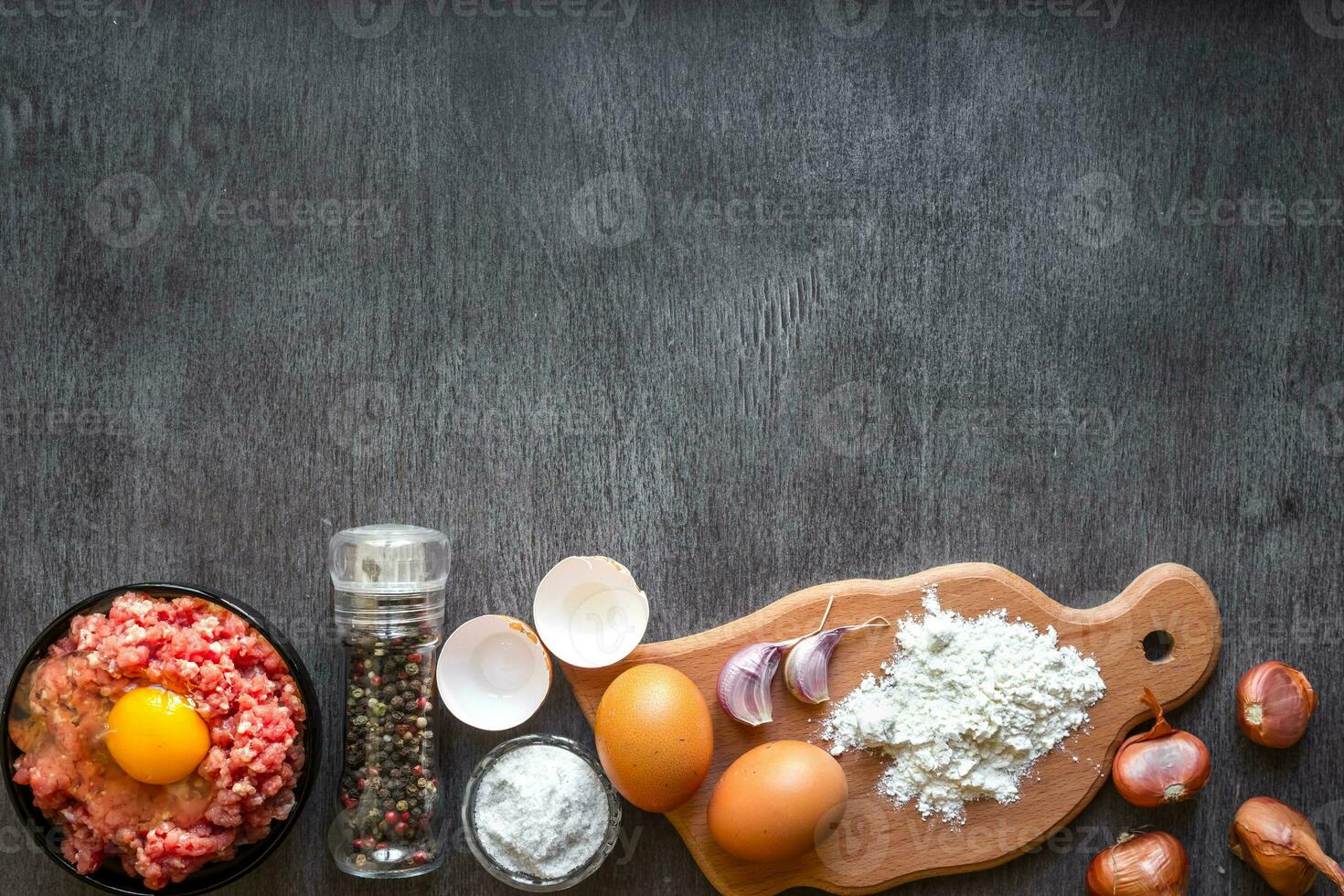 Raw minced meat with egg yolk, wooden cutting board on wooden background photo