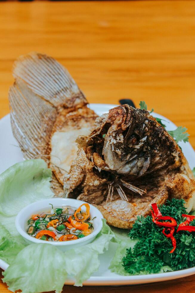 deep fried Gourami Fish served chilli sauce isolated on white background photo