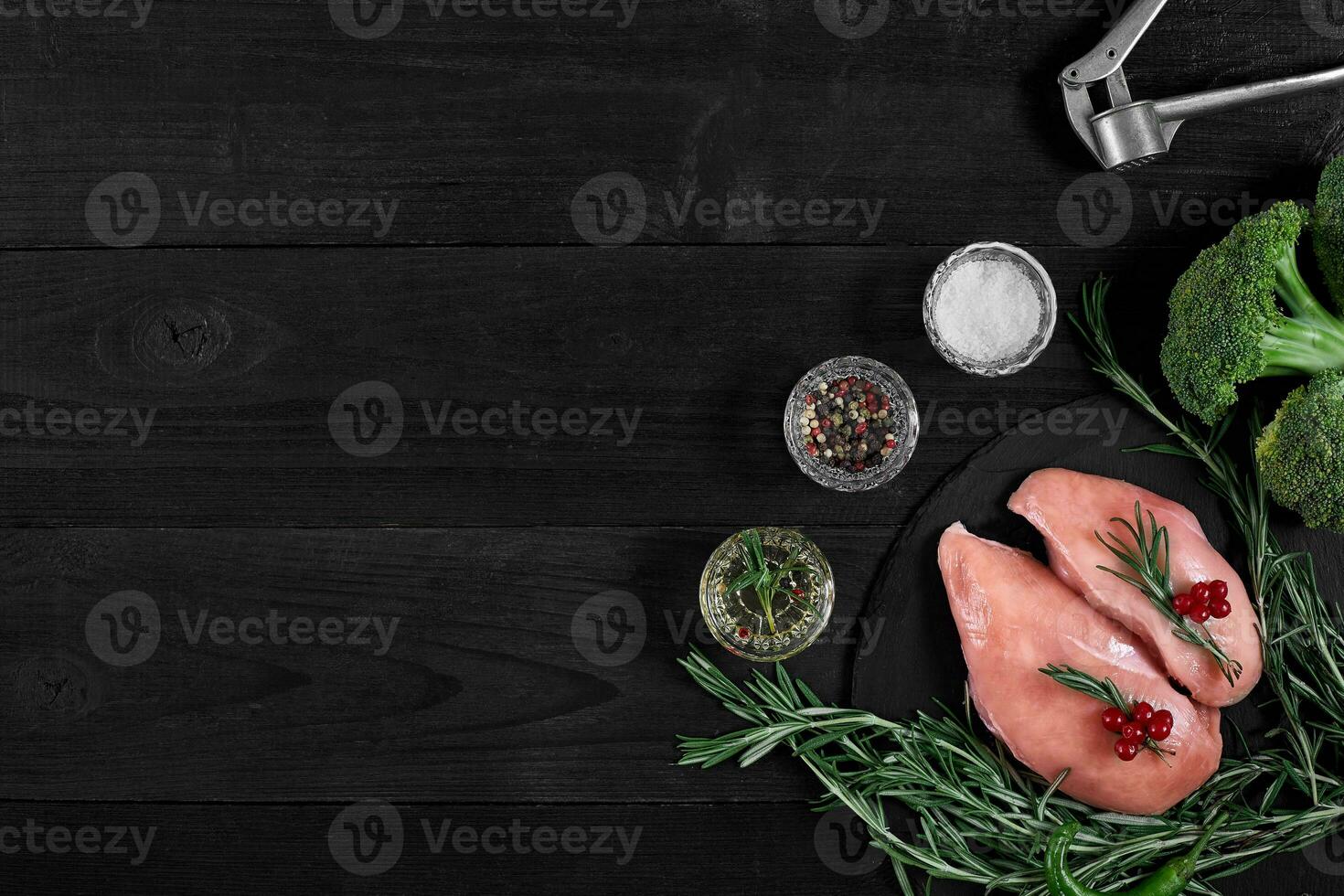 Cooking chicken breasts. On the table are spices - rosemary, red and black pepper. Concept - healthy food. photo