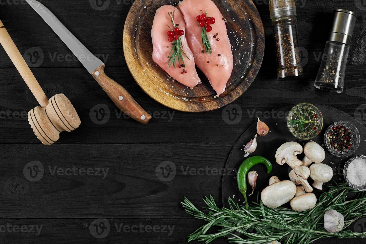 Raw chicken breast fillets on wooden cutting board with herbs and spices. Top view with copy space photo