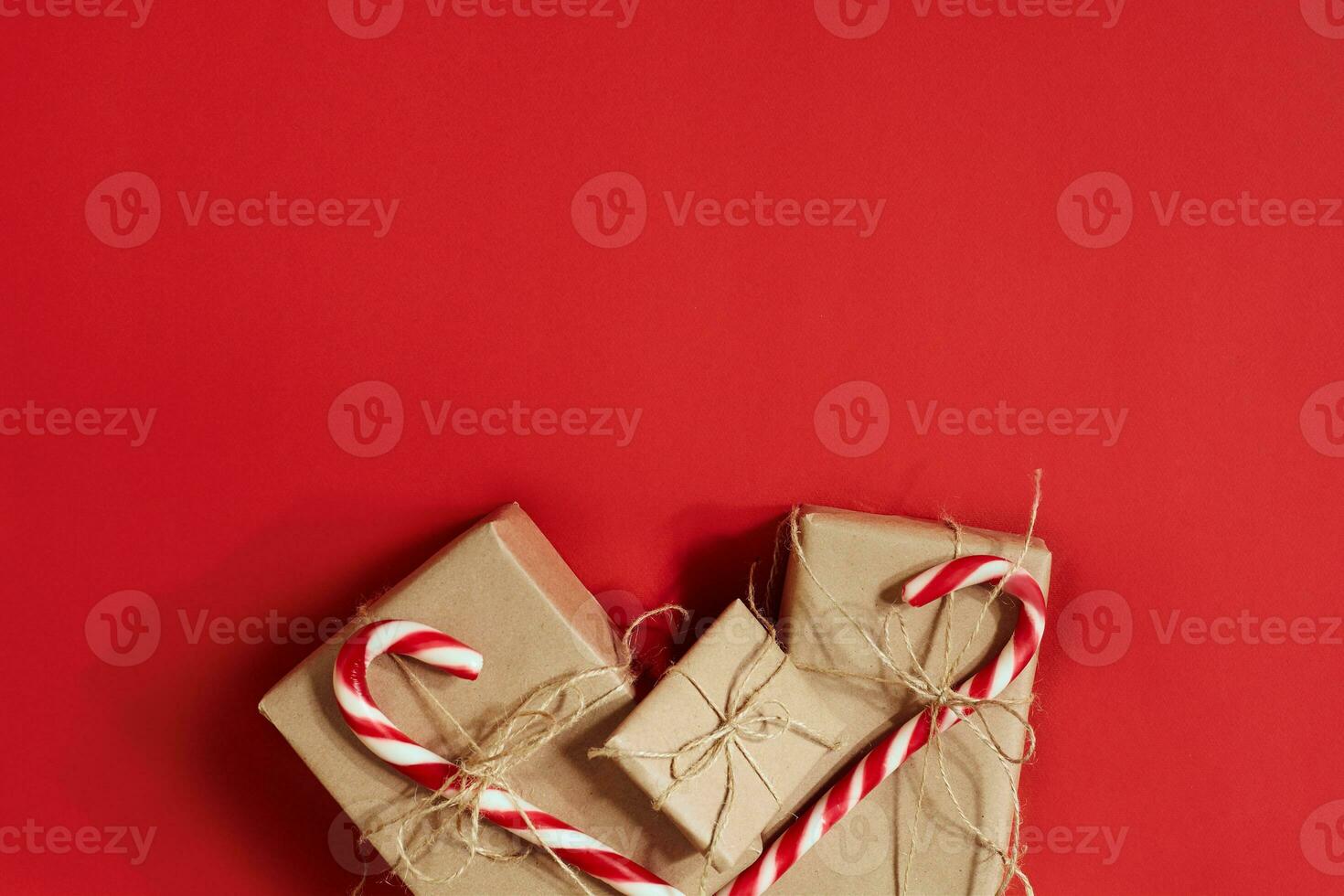 Christmas gifts on hot red background. Christmas and New Year theme. Place for your text, wishes, logo. Mock up. photo