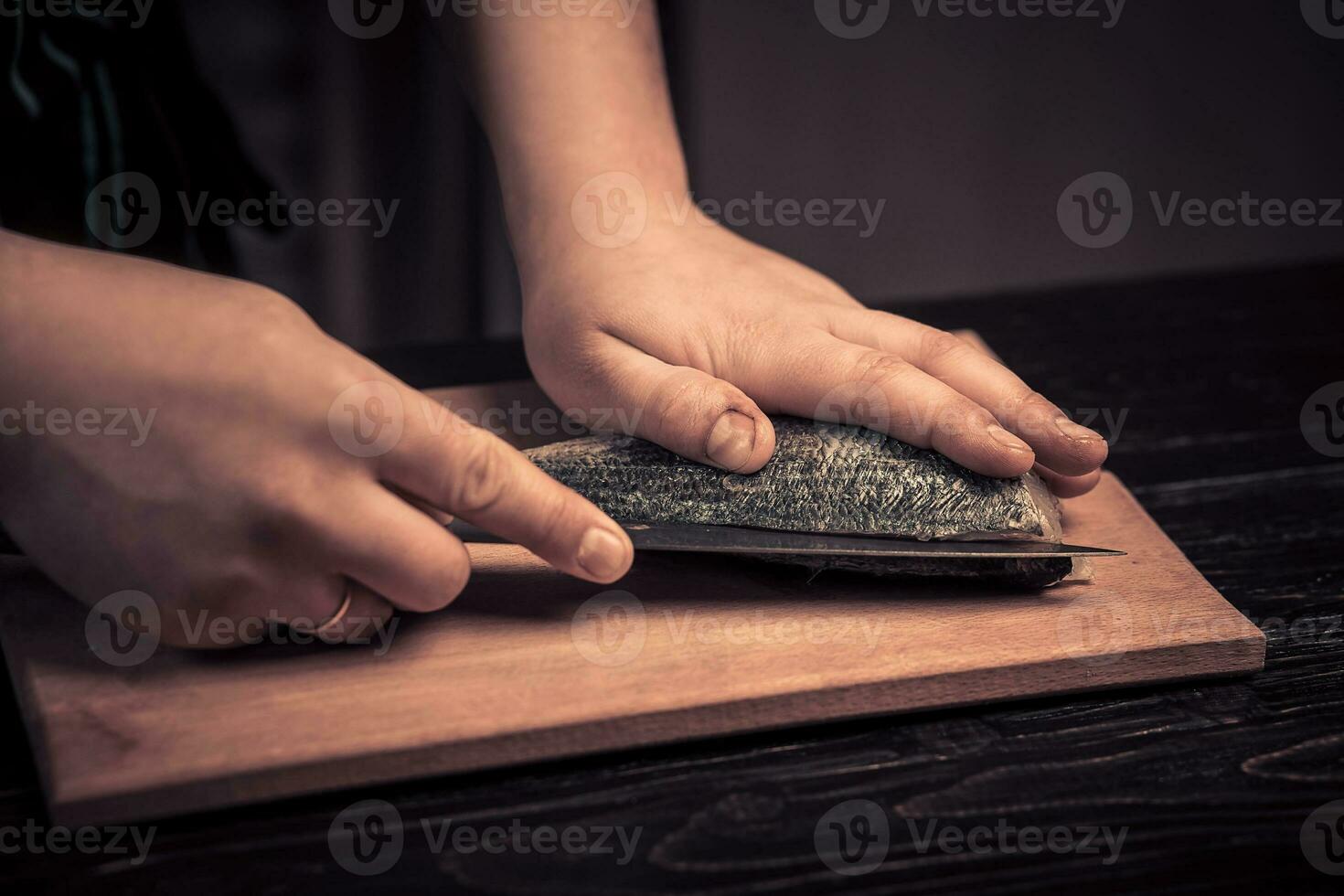 Chef cutting the fish on a board photo