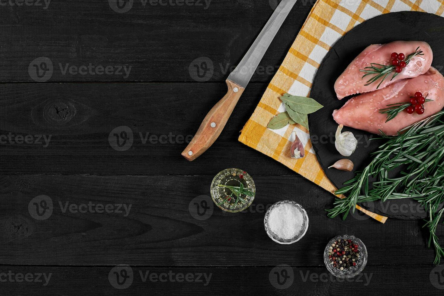 Raw chicken fillet with cooking ingredients on black slate table. Food background. Top view, copy space. photo