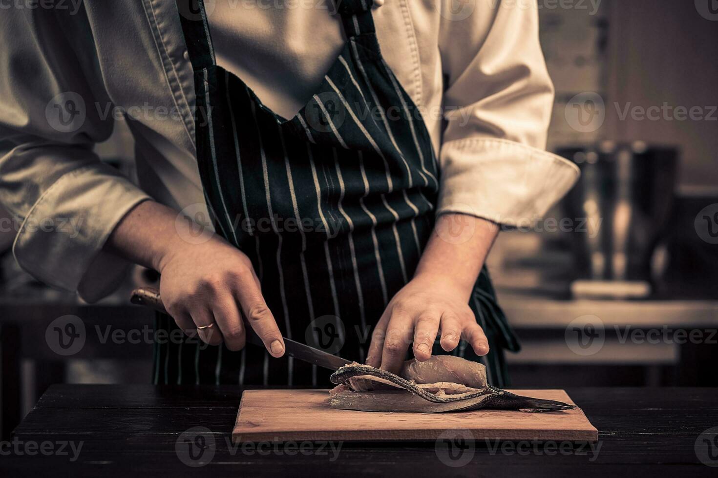 Chef cutting the fish on a board photo