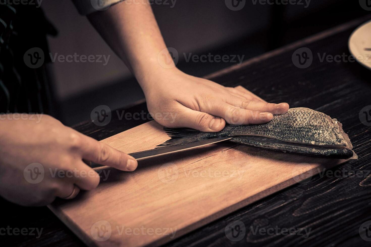 Chef cutting the fish on a board photo