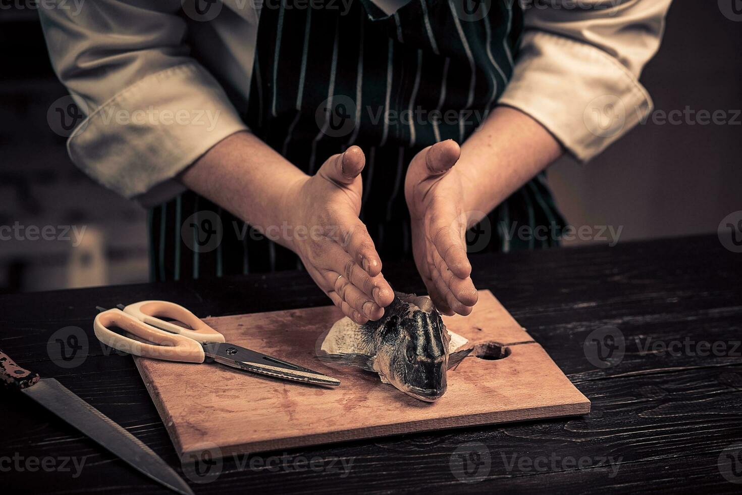 Chef cutting the fish on a board photo